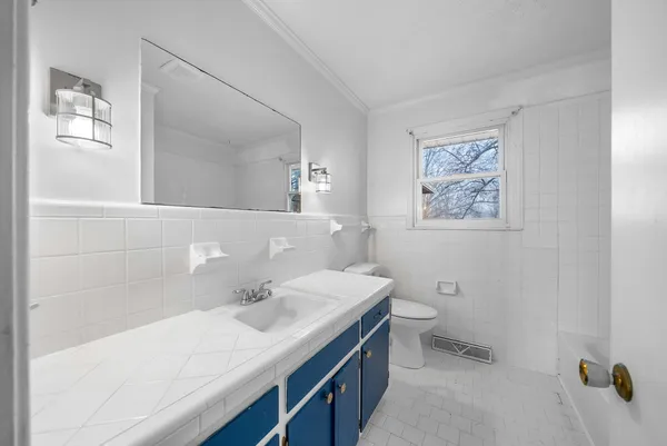 a bathroom with a sink a toilet and mirror