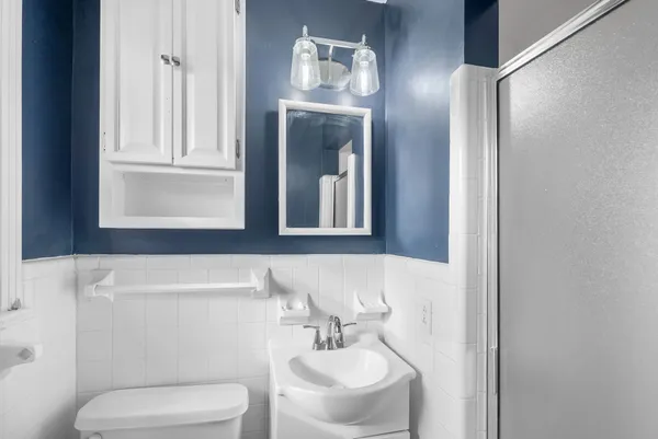 a bathroom with a toilet a sink and mirror