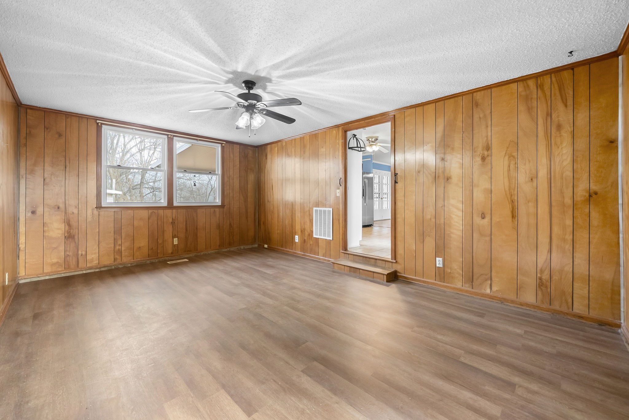 233 Pine Mountain Road Clarksville, TN 37042 - Photo 25 of 33 an empty room with wooden floor chandelier fan and windows