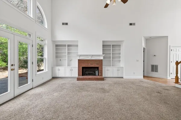 an empty room with a window and a fan