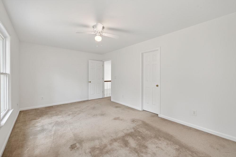 7512 Fieldstone Way Monroe, GA 30656 - Photo 34 of 49 an empty room with a chandelier fan and windows