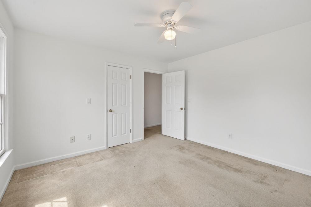 7512 Fieldstone Way Monroe, GA 30656 - Photo 38 of 49 an empty room with a ceiling fan and a window