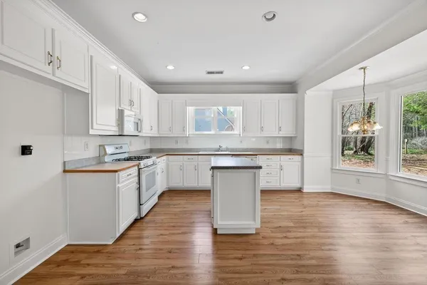 a kitchen with a white wooden cabinets and white appliances