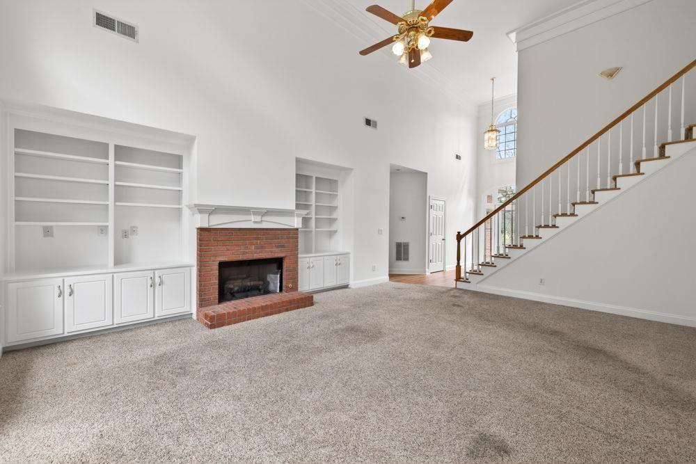 7512 Fieldstone Way Monroe, GA 30656 - Photo 5 of 49 a view of a livingroom with a fireplace a ceiling fan and windows