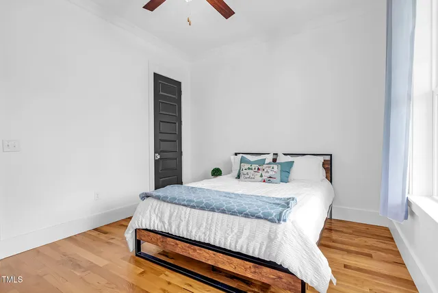 a spacious bedroom with a bed and ceiling fan