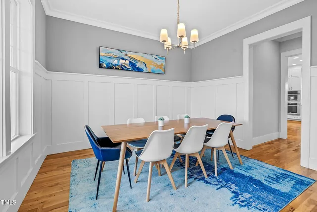 a view of a dining room with furniture wooden floor and a chandelier