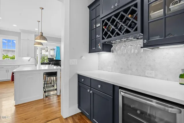 a large kitchen with stainless steel appliances kitchen island granite countertop a large kitchen island a stove a refrigerator a sink dishwasher and white cabinets with wooden floor