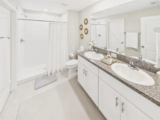 a spacious bathroom with a granite countertop sink and a mirror