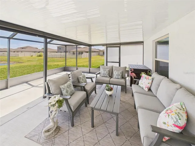 a living room with furniture and floor to ceiling windows