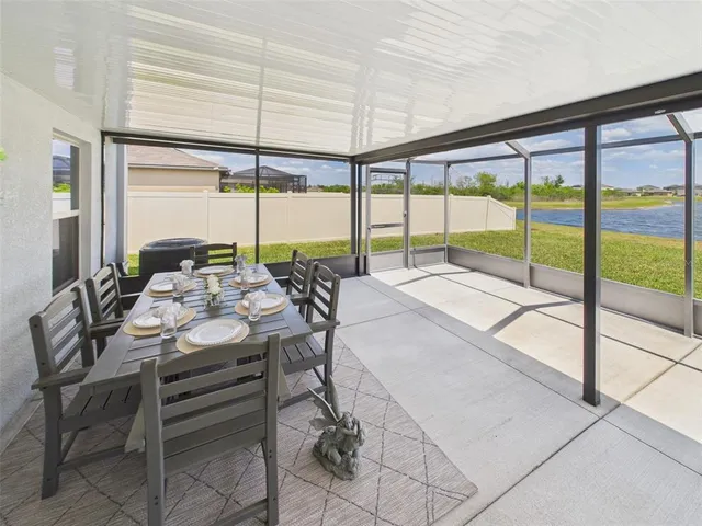 a dining room with furniture and large windows