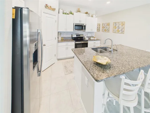 a kitchen with stainless steel appliances granite countertop a sink refrigerator and microwave