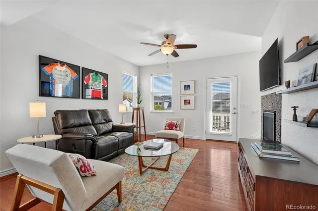 a living room with furniture a flat screen tv and a table