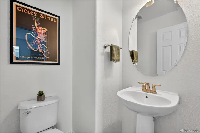 a bathroom with a sink and mirror with toilet