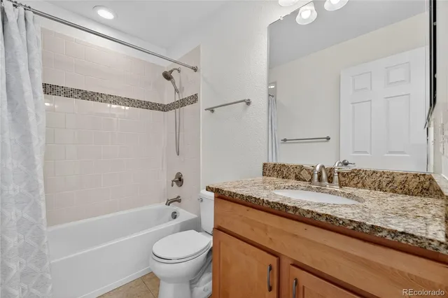 a bathroom with a granite countertop sink a toilet and shower