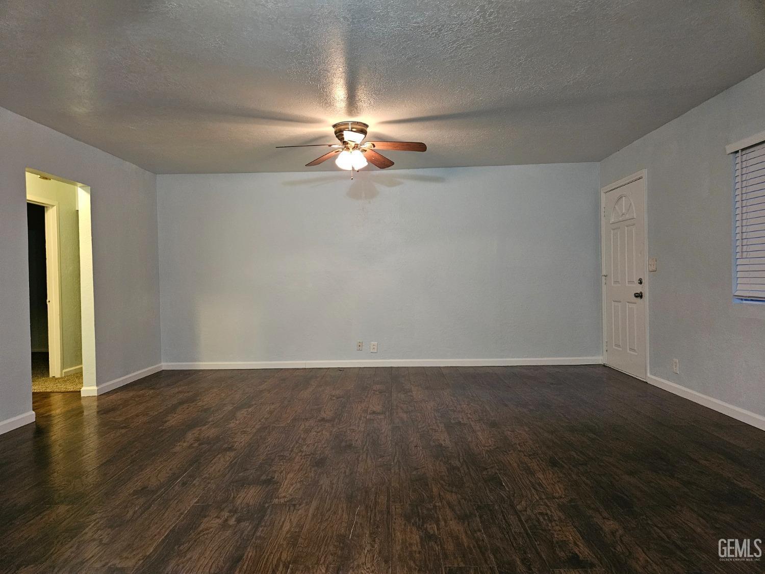 Undisclosed Address Wasco, CA 93280 - Photo 3 of 16 wooden floor in an empty room with a window