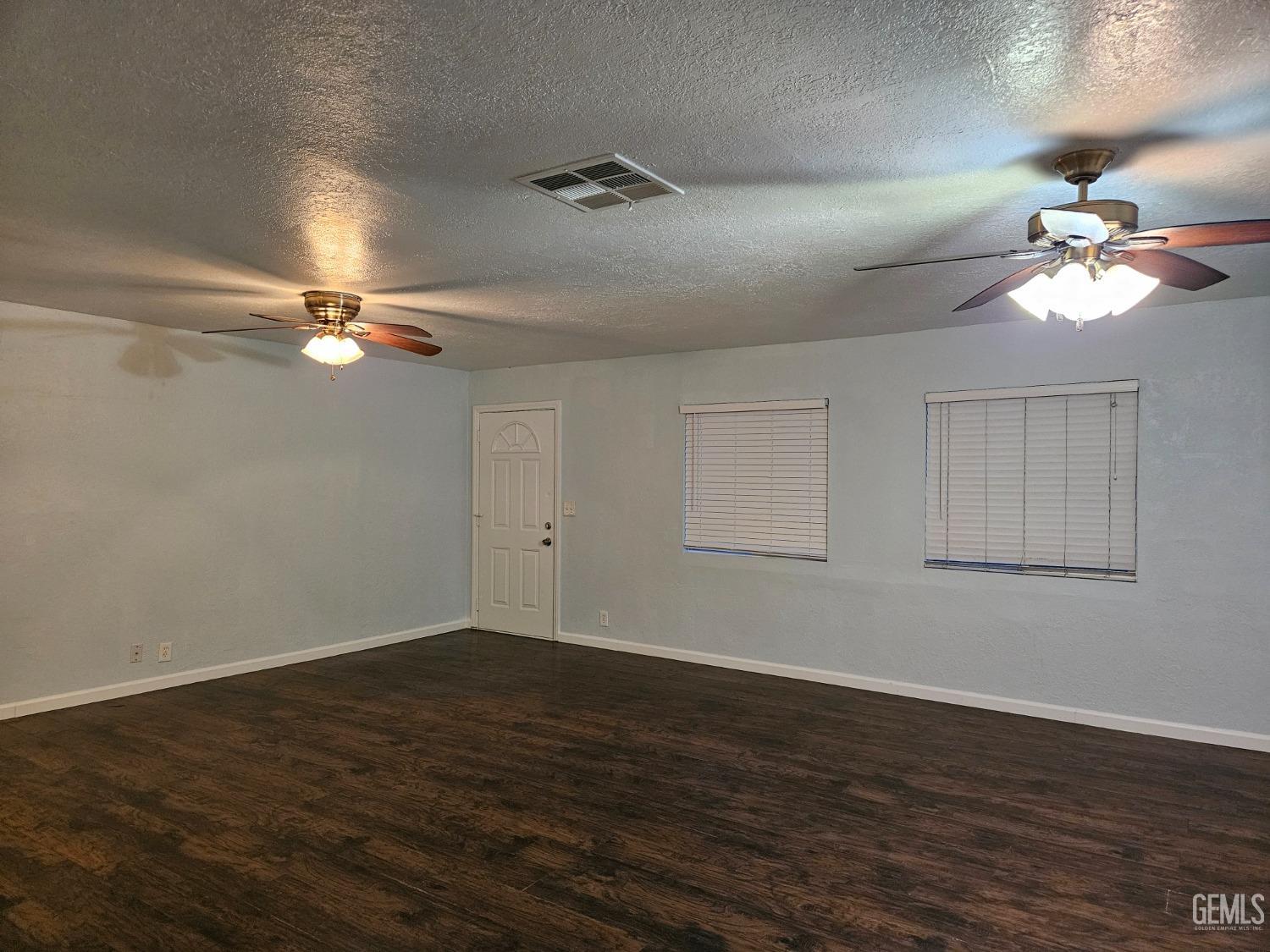 Undisclosed Address Wasco, CA 93280 - Photo 5 of 16 a view of a room with wooden floor and fan