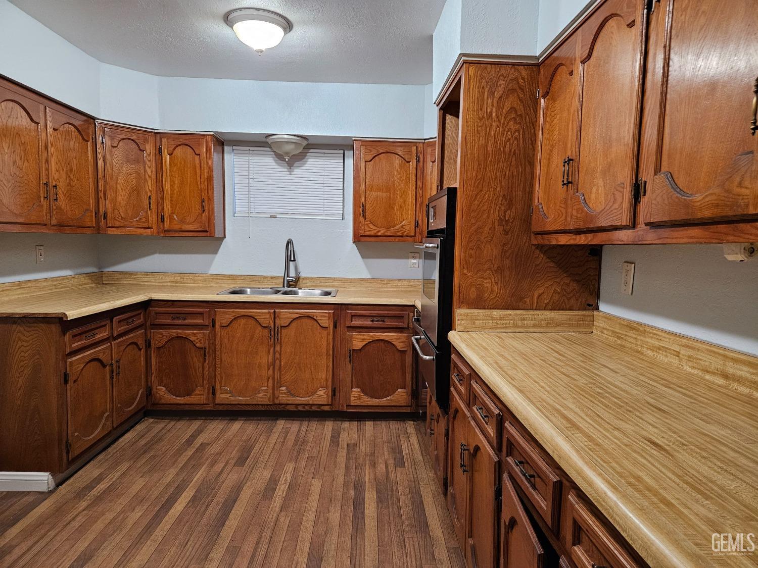 Undisclosed Address Wasco, CA 93280 - Photo 7 of 16 a kitchen with stainless steel appliances granite countertop a sink a stove and wooden cabinets
