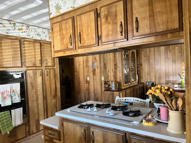 a kitchen with appliances cabinets and wooden floor