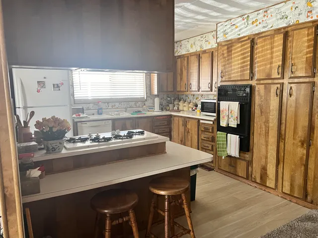 a kitchen with stainless steel appliances a table and chairs in it