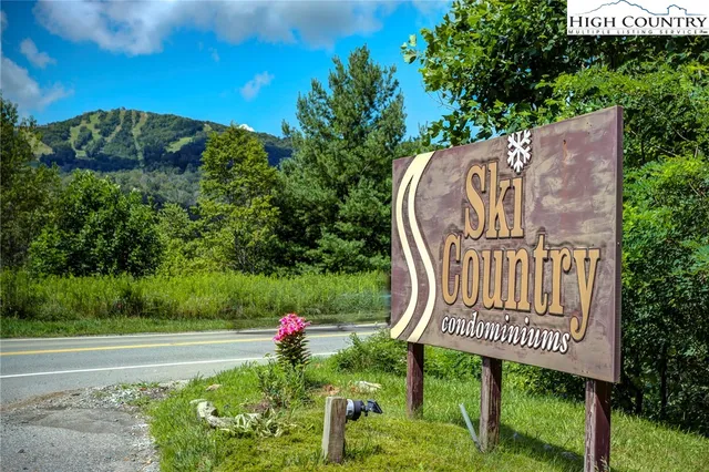 a view of a wooden bench sitting near a garden