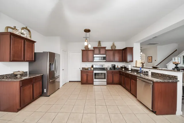 a large kitchen with stainless steel appliances and wooden cabinets