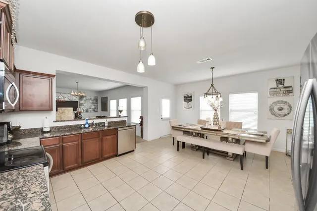 a large kitchen with kitchen island a large counter space a sink stainless steel appliances and cabinets