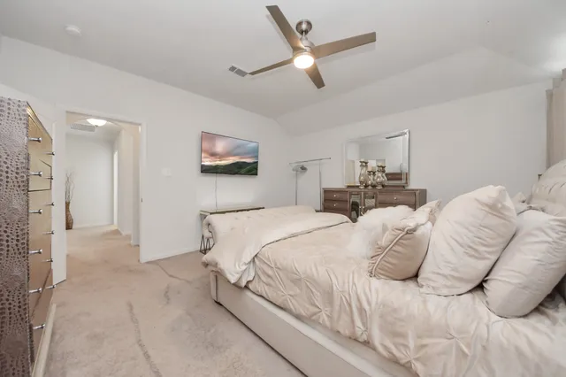 a bedroom with a large bed and a chandelier