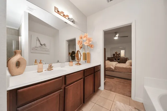 a en suite bathroom with a double vanity sink mirror and bathtub