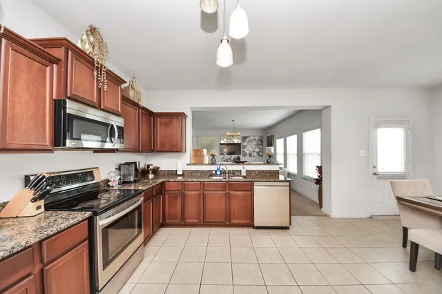 a kitchen with stainless steel appliances granite countertop a sink and cabinets