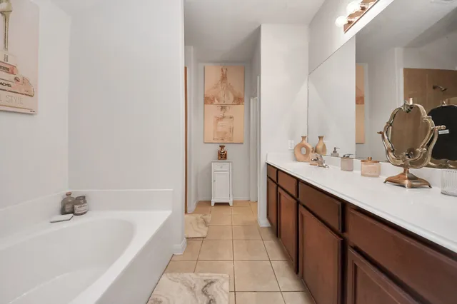 a bathroom with a tub sink and mirror