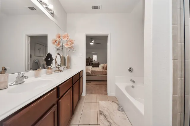 a bathroom with a tub sink and mirror