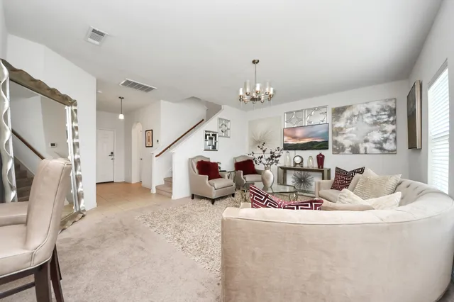 a living room with furniture and a chandelier
