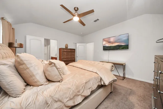 a bedroom with a large bed and a flat screen tv