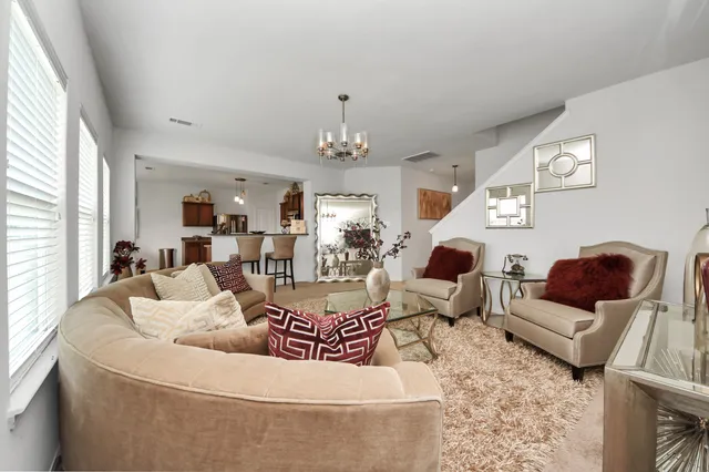 a living room with furniture and a chandelier