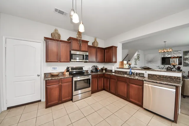 a kitchen with granite countertop appliances cabinets a sink and a counter top space
