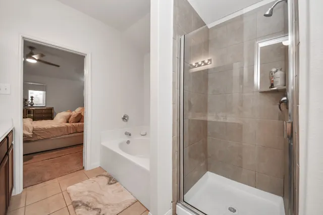 a bathroom with a tub shower and bedroom view