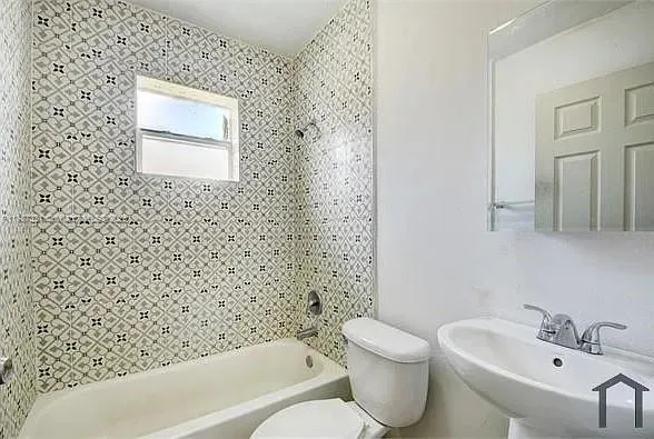a view of a refrigerator in kitchen and an empty room