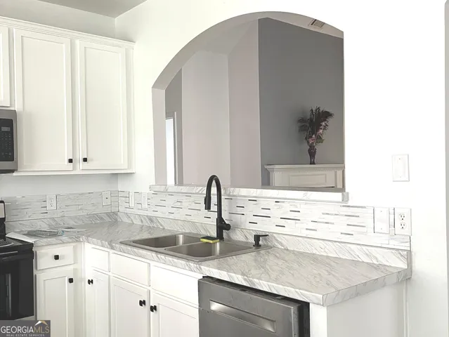 a kitchen with granite countertop a sink and cabinets