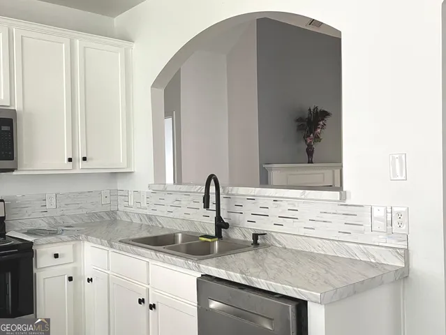 a kitchen with granite countertop a sink and cabinets