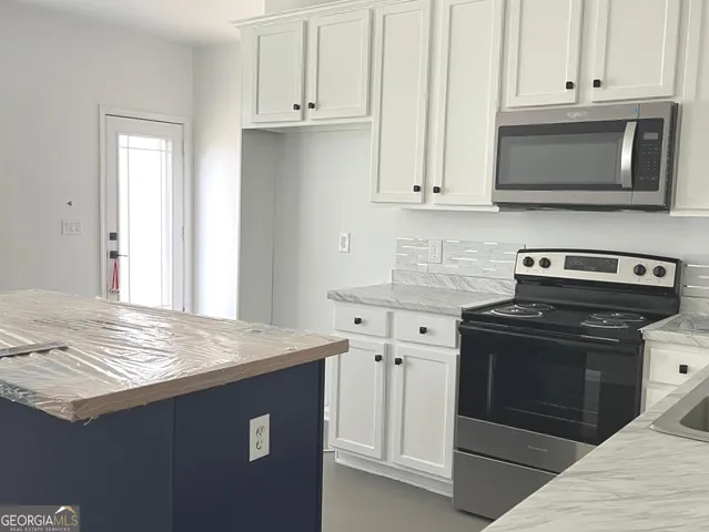 a kitchen with stainless steel appliances granite countertop a stove a microwave and oven