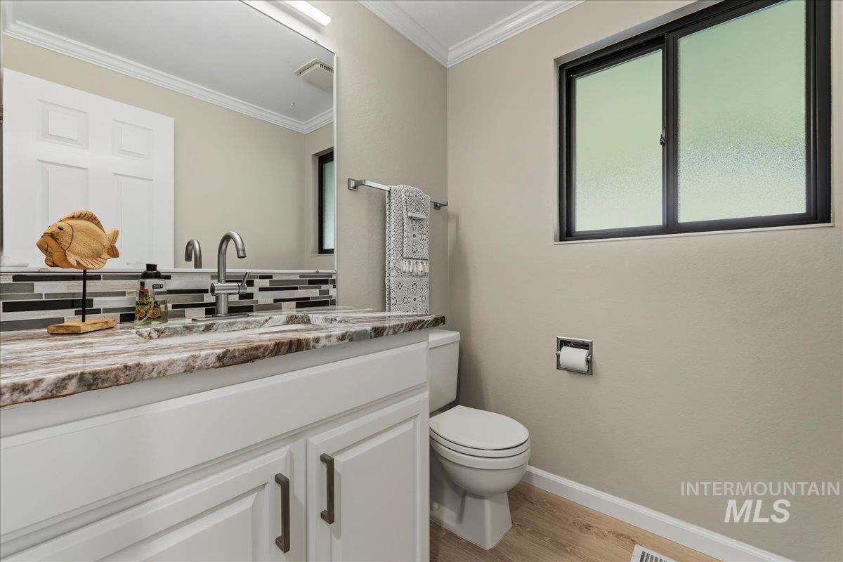 599 Pebble Beach Way Eagle, ID 83616 - Photo 19 of 44 Bathroom featuring a single vanity with a stone-finish countertop, undermount sink, and brushed nickel faucet