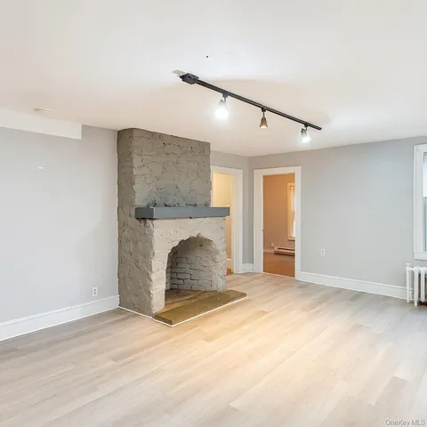 a view of an empty room with a fireplace and a window