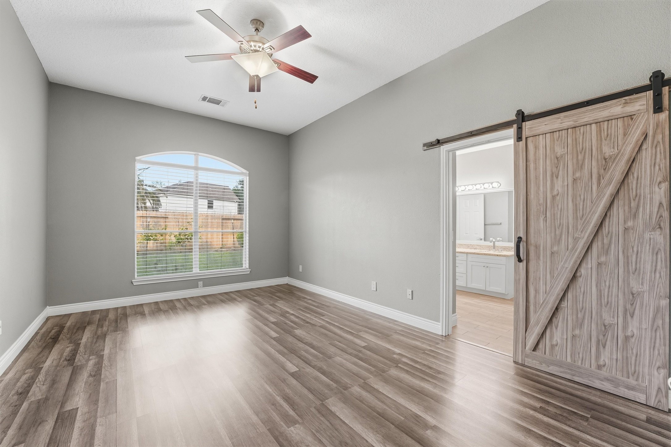 5719 Walkabout Way Katy, TX 77450 - Photo 14 of 25 A sliding barn door adds character while leading you into the ensuite bath.