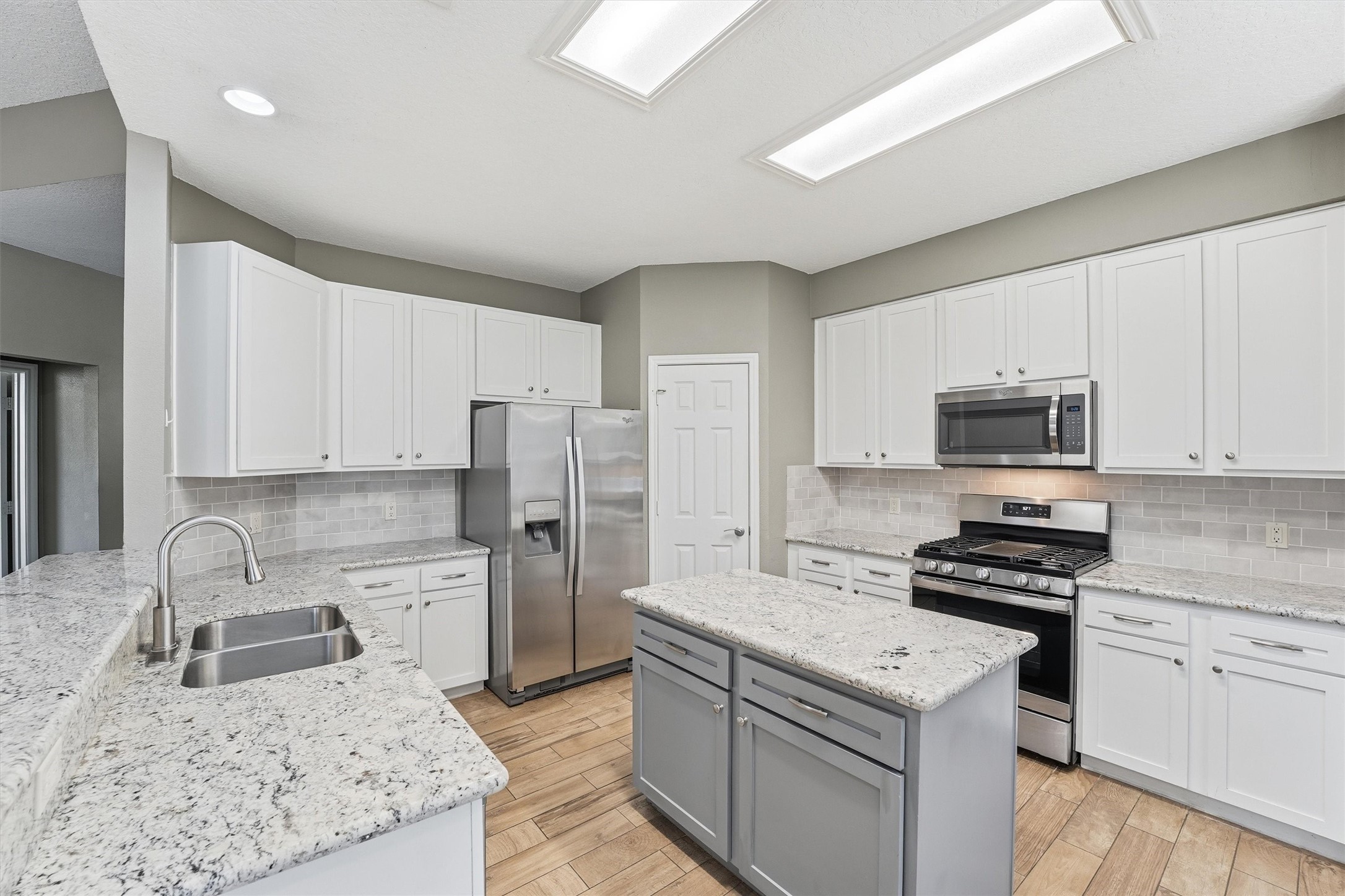 5719 Walkabout Way Katy, TX 77450 - Photo 10 of 25 Granite countertops, crisp white cabinetry, and stainless steel appliances create a fresh, timeless look. With abundant storage, tile backsplash, and an undermount sink, everything has its place and purpose.