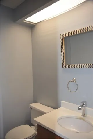 a bathroom with a toilet a sink and mirror
