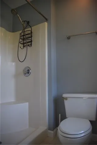 a white toilet sitting next to a shower