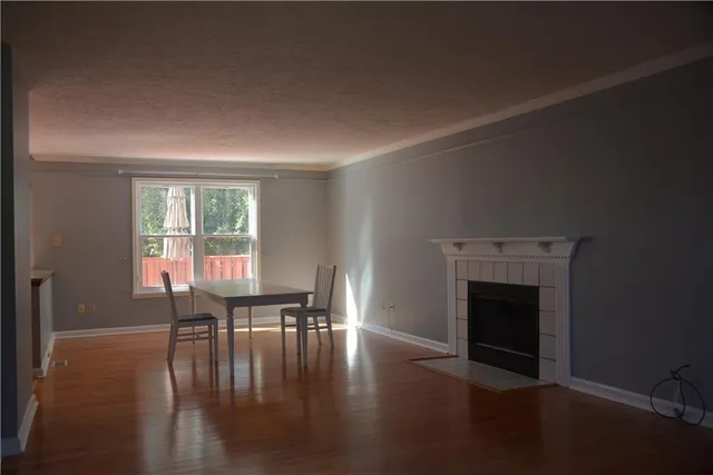 a dining room with furniture floor to ceiling window and wooden floor