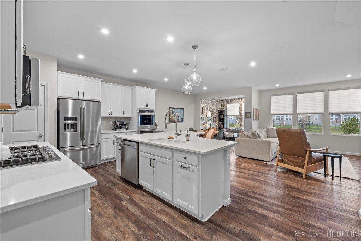 1255 Josiah Road Naperville, IL 60563 - Photo 7 of 39 a kitchen with stainless steel appliances kitchen island granite countertop a stove top oven a refrigerator a dining table and chairs with wooden floor