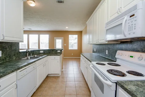 a kitchen with a stove a sink and a refrigerator