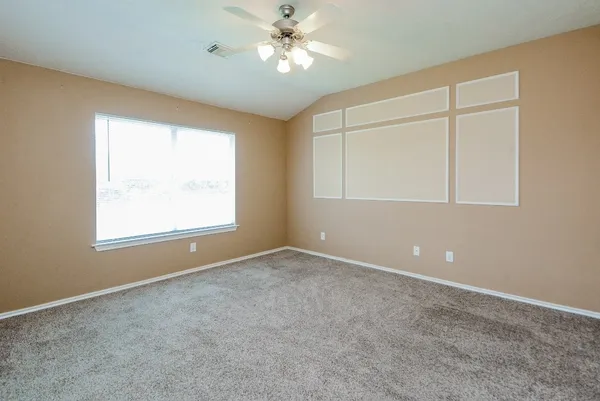 an empty room with a window and a fan